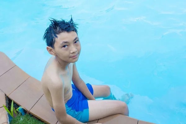 Asiatische junge sitzen an der Kante der die pool — Stockfoto