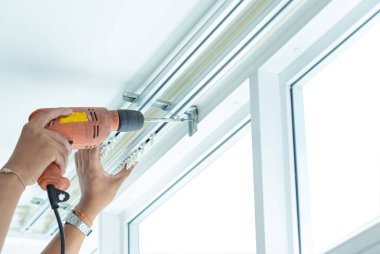 Profesyonel teknik tarafından perdeleri yüklemek için vida vidalar