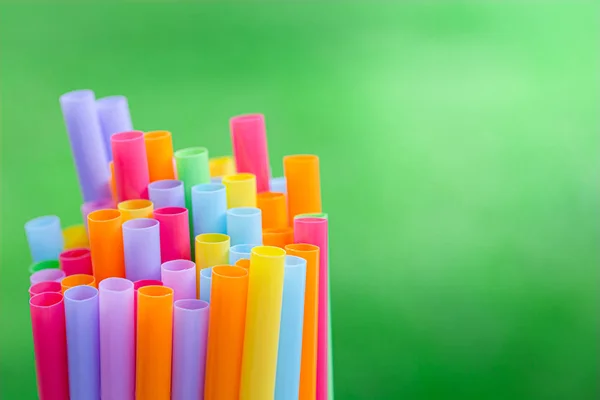 Meerdere kleur drinken rietjes op een groene gras achtergrond vervagen — Stockfoto