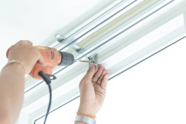 Profesyonel teknik tarafından perdeleri yüklemek için vida vidalar