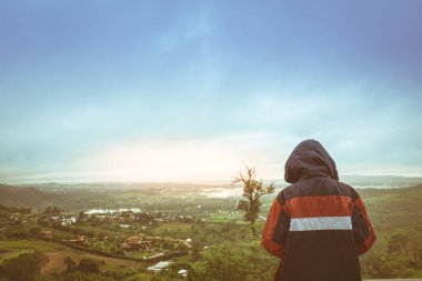 Mutlu Asyalı çocuk doğa arka planda bir başlık giyiyor