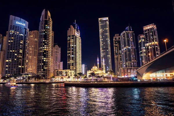 Dubai at night. Dubai marina, skylines Dubai Marina. Skyscrapers and Mosque of Dubai Marina in the evening. Ships and boats.