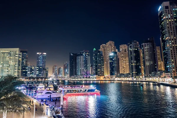 Dubai at night. Dubai marina, skylines Dubai Marina. Skyscrapers and Mosque of Dubai Marina in the evening. Ships and boats.