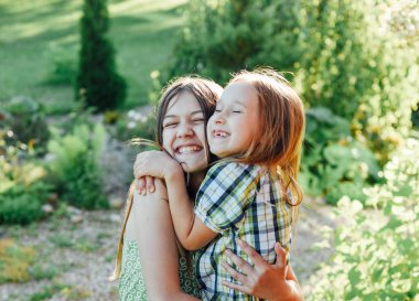 Açık havada birlikte eğleniyor ve sarılma iki sevimli kız kardeş