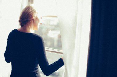 evde pencere duran genç çekici kadın