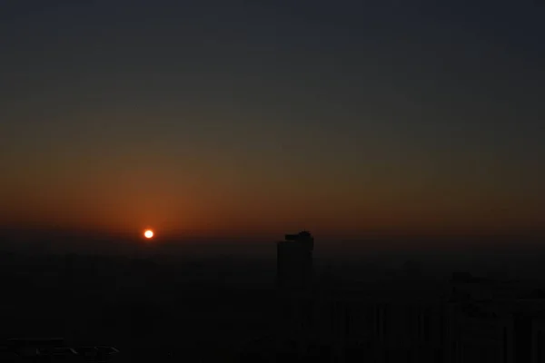 劇的な夕日の背景に都市の建物のシルエット — ストック写真