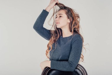 Stüdyoda parlak arka planda poz veren genç bir kız. 