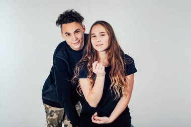 Stüdyoda beyaz arka planda poz veren genç bir çift. 