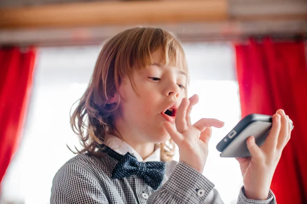 little boy playing on smartphone at home