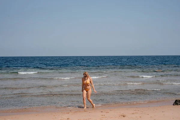 Νεαρή Γυναίκα Μαγιό Περπατώντας Στην Ακτή Της Θάλασσας Ζεστή Ηλιόλουστη — Φωτογραφία Αρχείου