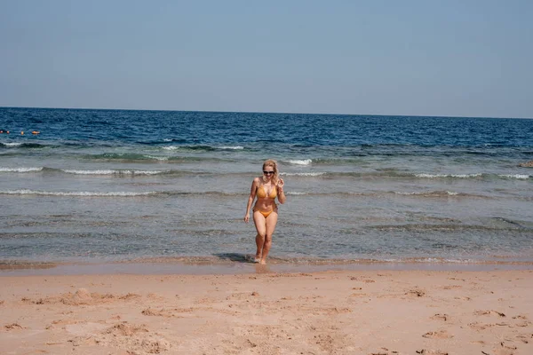 Νεαρή Γυναίκα Μαγιό Περπατώντας Στην Ακτή Της Θάλασσας Ζεστή Ηλιόλουστη — Φωτογραφία Αρχείου