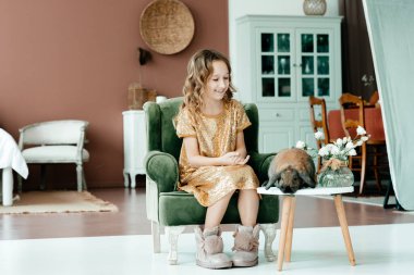 Evdeki kanepede oturan kız.