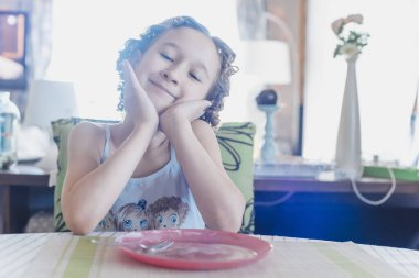 Boş tabağı olan küçük tatlı bir kız.