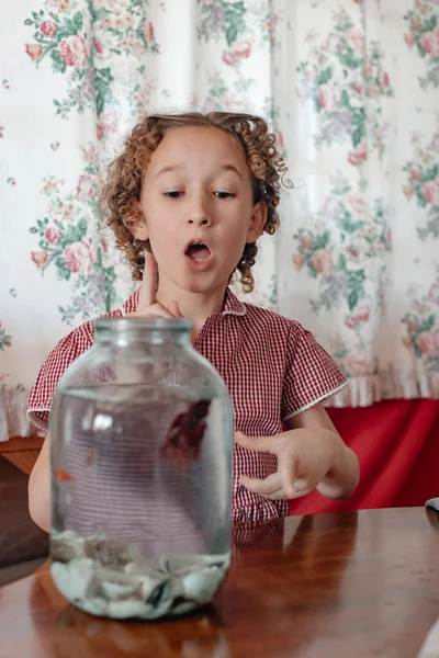 little girl with fish in glass jar