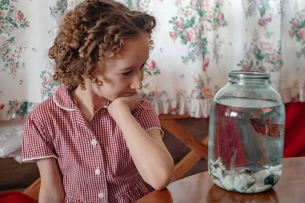 little girl and fish in glass jar