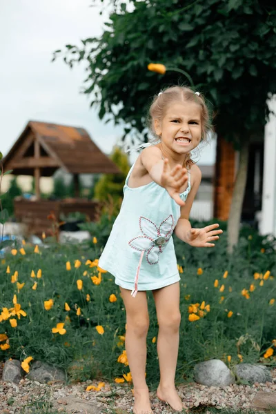 Dívka Venku Létě Šatech Grimasy Odpustky Pozadí Jsou Květiny Koncept — Stock fotografie