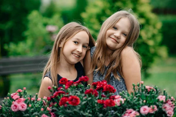 花のある公園の2人の幸せな女の子 — ストック写真