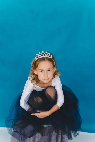 Uma Menina Vestido Magnífico Senta Fundo Uma Parede Azul Uma — Fotografia de Stock