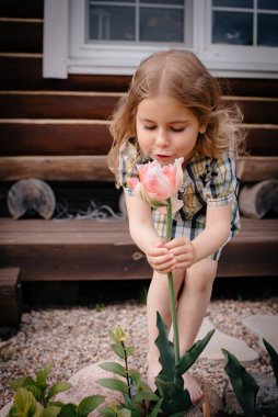 Köyde küçük bir kız ve büyükannesi çiçek kokluyor. Tasasız çocukluk. Yazın kırsalda dinleniriz. Lale ellerinde..
