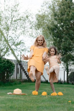 Elbiseli anne ve kızı çimenlikteki yazlık evde dinleniyor ve keyif alıyorlar. Yaz tatili.