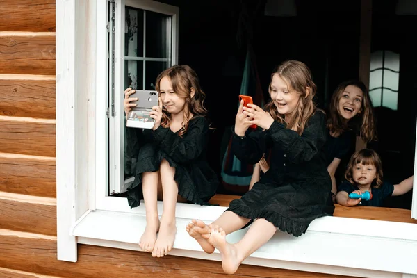 Маленькие Девочки Черных Платьях Сидят Подоконнике Летнем Домике Фотографируют Природу — стоковое фото