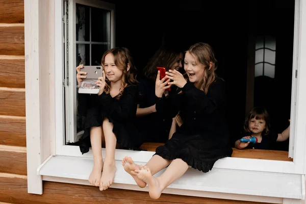 Kleine Meisjes Zwarte Jurken Zitten Vensterbank Het Zomerhuis Foto Maken — Stockfoto