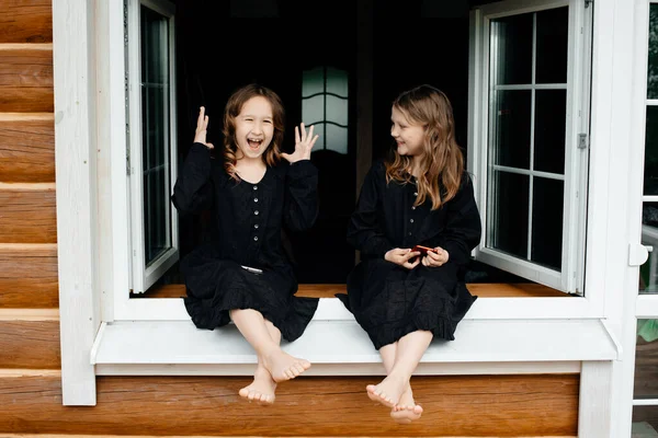 Las Niñas Con Vestidos Negros Están Sentadas Ventana Hablando Por —  Fotos de Stock