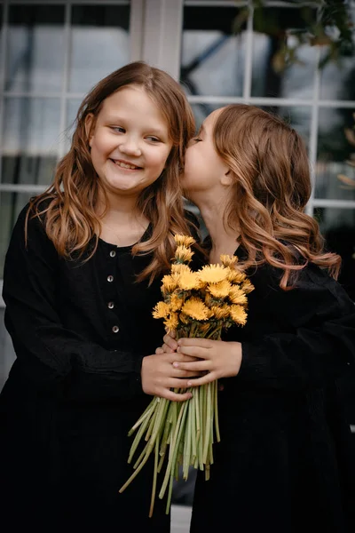 Two Girlfriends Black Dresses Bouquet Flowers Hands Whispering Something Each — Stock Photo, Image