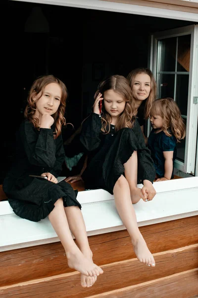 Young Attractive Mother Three Little Girls Black Dresses Sitting Windowsill — Stock Photo, Image