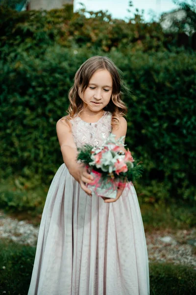 Una Niña Con Vestido Largo Sostiene Flores Sus Manos Fondo —  Fotos de Stock