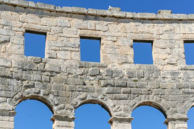 Antik Roma amfi tiyatro ile mavi gökyüzüne karşı kemerli pencere eşiği duvarına