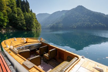 Abhazya, Gürcistan, 17 Eylül 2017: güzel nadir ahşap sürat teknesi göl Ritsa dağlardaki arka plan üzerinde