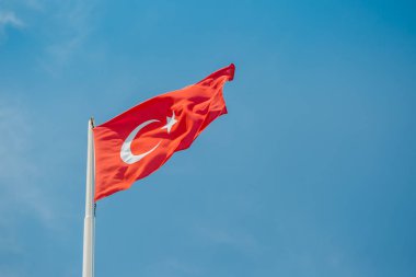 Türkiye'nin büyük bayrağı'nın Akdeniz kıyısında mavi gökyüzü rüzgar sallıyor