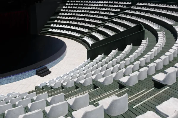 The grandstands of a modern summer outdoor amphitheater and a stage for small entertainment events