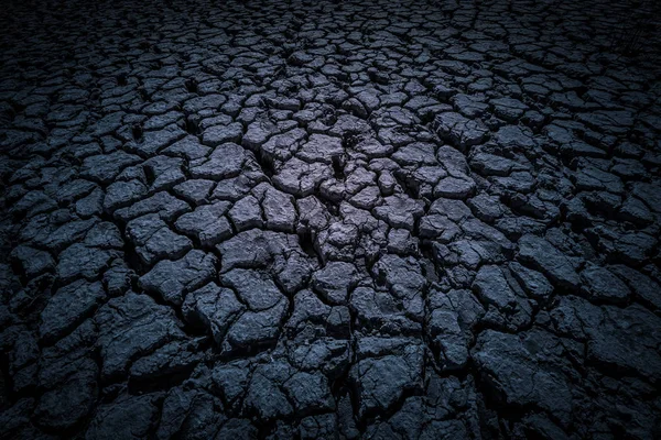 Black land, humus, covered with deep cracks in the dark as background or backdrop