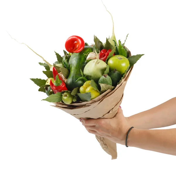 Original beautiful bouquet of vegetables and fruits in the hands of a girl on a white background