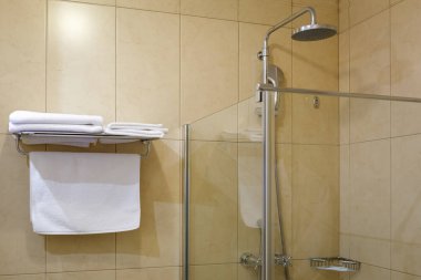 Havlu raf ve şeffaf duş ünitesi otel banyoda