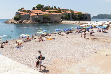 Karadağ, Budva, Sveti Stefan, 02 Ağustos 2014: pitoresk ünlü St. Stephen Island yakınındaki plaj görünümünü gün güneşli yaz