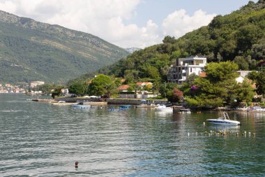 Donja Lastva, Tivat, Karadağ, 06 Ağustos 2014: Çevre Tivat şehir, sahilde evleri, sessiz bir güneşli yaz günü turist ile küçük bir plaj