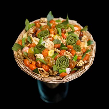 Çeşitli lezzetli kurutulmuş meyveler siyah bir zemin üzerine bir buket şeklinde orijinal hediye