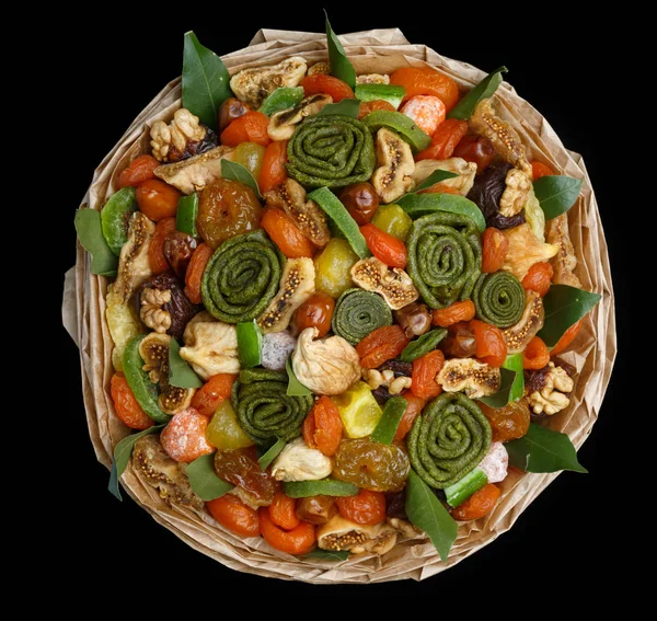 Özgün Hediyelik çeşitli lezzetli kurutulmuş meyveler siyah bir zemin üzerine bir buket şeklinde. Üstten görünüm