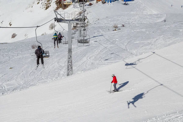 俄罗斯多巴伊 2018年2月27日 在阳光明媚的冬日 双椅滑雪缆车与人们一起在滑雪场上 — 图库照片