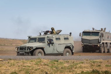 Kadamovskiy eğitim alanı, Rostov bölgesi, Rusya, 26 Ağustos 2018: Uluslararası askeri teknik forum ordu-2018. Çok amaçlı zırhlı araç Gaz-233014 kaplan ve Kamaz-63968 askeri eğitim toprağa hareket ediyor