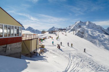 Dombay, Rusya, 27 Şubat 2018: Birçok kayakçılar ve snowboard düşkünleri dağın bir güneşli kış gününde rest