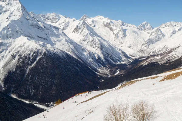 Skiërs Snowboarders Rijden Besneeuwde Hellingen Tegen Achtergrond Van Toppen Van — Stockfoto