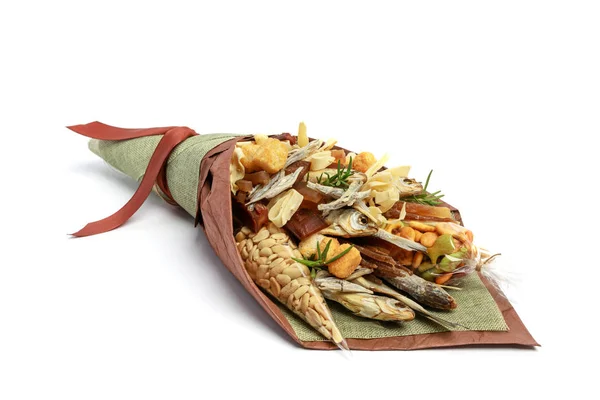 Original bouquet consisting of dried salted fish, salted peanuts, crackers, dried bread and other beer snacks isolated on white background as male gift