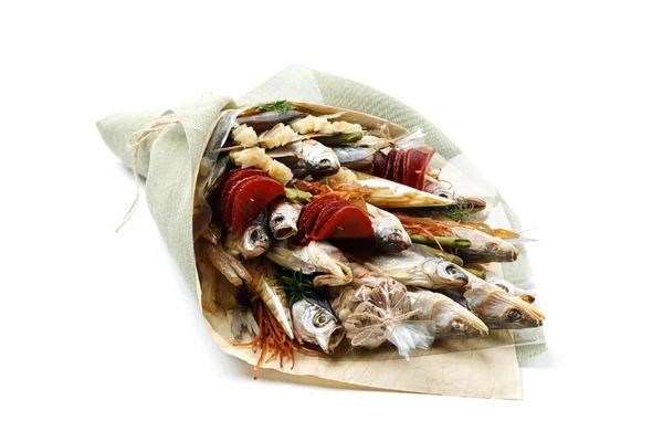 Snacks, dried fish, pistachios packed in the form of a bouquet on a white background
