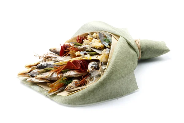 Snacks, dried fish, pistachios packed in the form of a bouquet on a white background. Side view