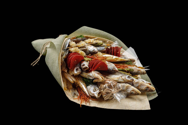 Dried fish, snack, chips, pistachios as a gift for a bachelor party on a black background