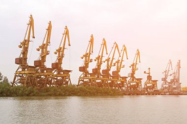Birçok eski gantry vinçler nehir kıyısında bir limanda üst üste durmak. Tonlu görüntü